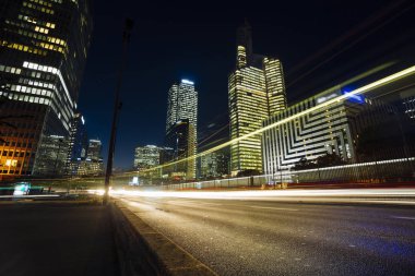 Paris iş içinde gökdelenler La Defense bölge. Avrupa gece cityscape dinamik sokak trafik, araba ışıklar ve modern binalar cam cephe ile. Ekonomi, Maliye, Ulaştırma kavramı. Tonda