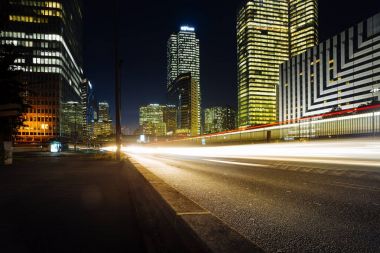 Paris iş içinde gökdelenler La Defense bölge. Avrupa gece cityscape dinamik sokak trafik, araba ışıklar ve modern binalar cam cephe ile. Ekonomi, Maliye, Ulaştırma kavramı. Tonda