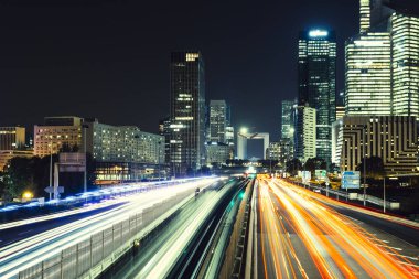 Paris iş içinde gökdelenler La Defense bölge. Avrupa gece cityscape dinamik sokak trafik, araba ışıklar ve modern binalar cam cephe ile. Ekonomi, Maliye, Ulaştırma kavramı. Tonda