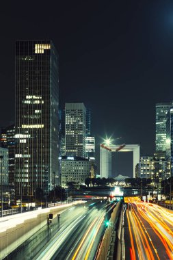 Paris iş içinde gökdelenler La Defense bölge. Avrupa gece cityscape dinamik sokak trafik, araba ışıklar ve modern binalar cam cephe ile. Ekonomi, Maliye, Ulaştırma kavramı. Tonda