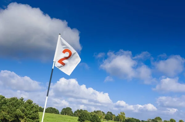 Pohled zelené golfové hřiště, díry a vlajku na za jasného slunečného dne. Sport, odpočinek, rekreaci a volný čas konceptu. Letní krajina s paprsky — Stock fotografie