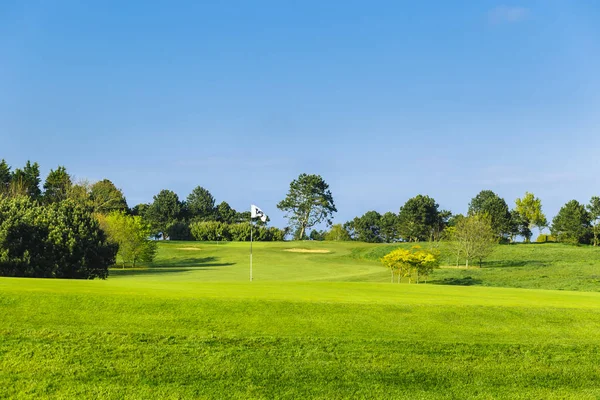 Vista geral de um campo de golfe verde em um dia ensolarado brilhante. Paisagem de verão idílica. Esporte, relaxamento, recreação e lazer conceito — Fotografia de Stock