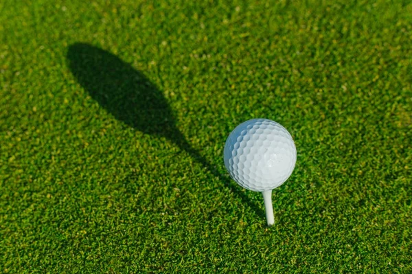 Мяч для гольфа на зеленом поле. Закрывай. Спорт, отдых, отдых и досуг — стоковое фото