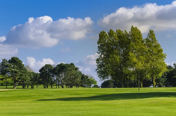 Celkový pohled na zelené golfové hřiště za jasného slunečného dne. Idylické letní krajina. Sport, relax, odpočinek a volný čas koncepce — Stock fotografie