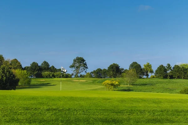 Vista geral de um campo de golfe verde em um dia ensolarado brilhante. Paisagem de verão idílica. Esporte, relaxamento, recreação e lazer conceito — Fotografia de Stock