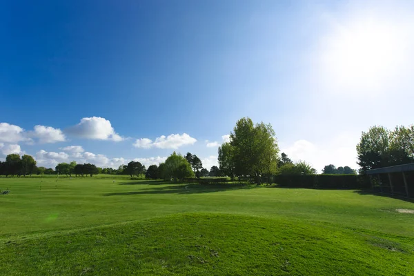 Algemeen beeld van een groene golfbaan op een zonnige dag. Idyllische zomer landschap. Sport, ontspanning, recreatie en vrije tijd concept — Stockfoto