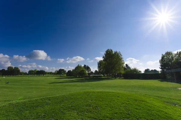 Vista geral de um campo de golfe verde em um dia ensolarado brilhante. Paisagem de verão idílica. Esporte, relaxamento, recreação e lazer conceito — Fotografia de Stock