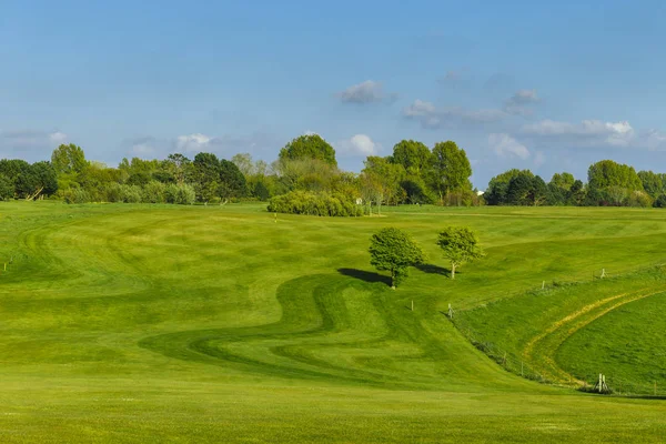 Celkový pohled na zelené golfové hřiště za jasného slunečného dne. Idylické letní krajina. Sport, relax, odpočinek a volný čas koncepce — Stock fotografie