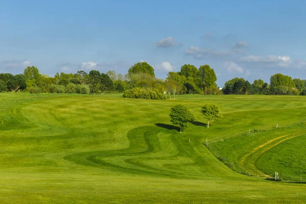 Vista geral de um campo de golfe verde em um dia ensolarado brilhante. Paisagem de verão idílica. Esporte, relaxamento, recreação e lazer conceito — Fotografia de Stock