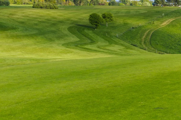 Vista geral de um campo de golfe verde em um dia ensolarado brilhante. Paisagem de verão idílica. Esporte, relaxamento, recreação e lazer conceito — Fotografia de Stock