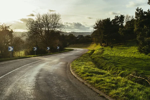 Asphalt curved road passing through the fields in the region of Normandy, France. Landscape in autumn sunny day. Toned — Stock Photo, Image