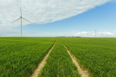 Rüzgar türbinleri bir santral elektrik üretimi için Normandy, Fransa için. Yenilenebilir enerji kaynakları kavramı. Ülke güneşli manzara. Çevre dostu elektrik üretimi. Tonda