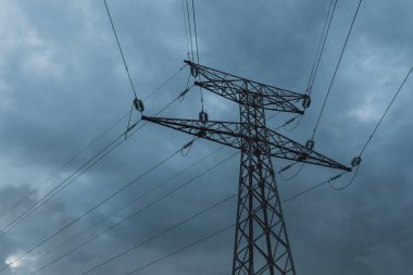 Yüksek gerilim enerji hatları ve enerji nakil direkleri bulutlu bir günde. Polonyalılar Havai hatları ve siluetleri dusk içinde. Elektrik üretim ve dağıtım. Elektrik Sanayi ve doğa kavramı