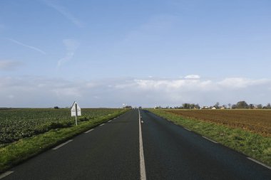 Normandy, Fransa bölgesi alanlarına buradan geçen asfalt yol. Sonbahar güneşli bir günde manzara. Tonda