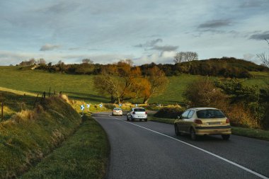 Normandy, Fransa bölgesi ormanda geçen arabalar ile eğri yol asfalt. İçinde sonbahar günü manzara. Tonda