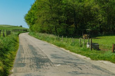 Yeşil tarım alanları üzerinden geçen ülke yol boş asfalt. Fransa'da bir güneşli bahar gününde kırsal manzara. Çevre dostu tarım, Sanayi Tarım, yol ağ konsepti