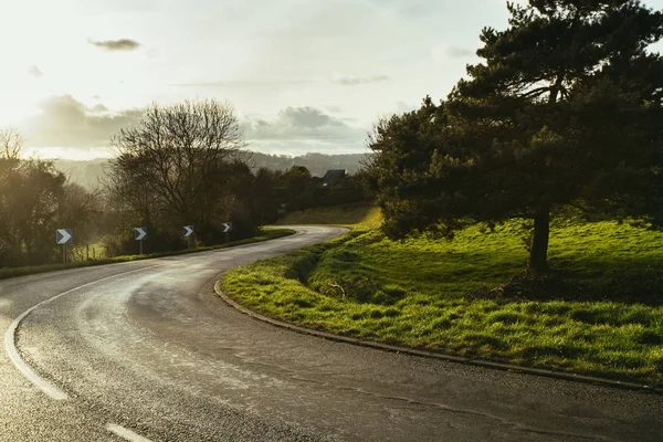 Asphalt curved road passing through the fields in the region of Normandy, France. Landscape in autumn sunny day. Toned — Stock Photo, Image