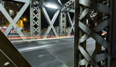 Şehirde bir köprünün çelik konstrüksiyon altında asfalt yol. Gece araba tünelde ışık yollar ile kentsel sahne. Tonda