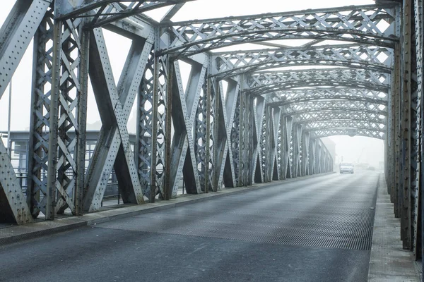 Costruzione in metallo del ponte della città in una giornata nebbiosa a Dieppe, Francia. Strada asfaltata vuota nel tunnel. Scenario urbano, vita cittadina, trasporti e traffico. Tonica — Foto Stock