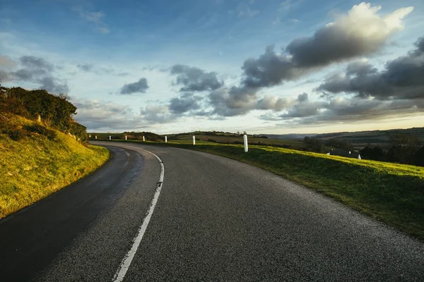 Asphalt curved road passing through the fields in the region of Normandy, France. Landscape in autumn sunny day. Toned — Stock Photo, Image