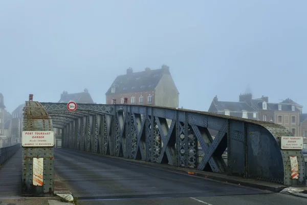 Cars passing on the asphalt road through the city bridge tunnel on a foggy day in Dieppe, France. Urban scene, city life, transport and traffic concept. Toned — Stock Photo, Image