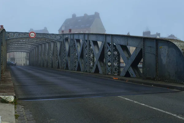 Автомобили, проходящие по асфальтовой дороге через туннель городского моста в туманный день в Дьепе, Франция. Городская сцена, городская жизнь, транспорт и концепция движения. Toned — стоковое фото