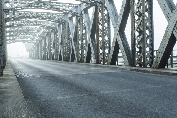 Construcción metálica del puente de la ciudad en un día de niebla en Dieppe, Francia. Carretera de asfalto vacía en el túnel. Escena urbana, vida urbana, transporte y concepto de tráfico. Tonificado — Foto de Stock