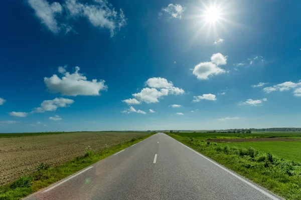 빈 아스팔트 국가로 통과 녹색 농업 분야는 화창한 날에 노르망디, 프랑스. 시골 풍경 푸른 하늘, 태양 열으로도 네트워크와 수송 개념 — 스톡 사진