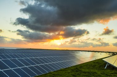 Normandy, Fransa için bulutlu gökyüzü ile gündoğumu, güneş panelleri. Güneş enerjisi, modern elektrik enerjisi üretim teknolojisi, yenilenebilir enerji kavramı. Çevre dostu elektrik üretimi