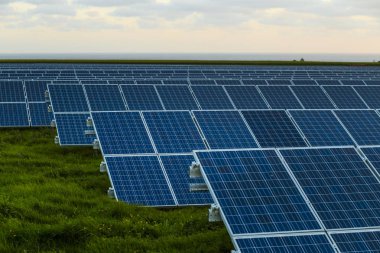 Normandy, Fransa için bulutlu gökyüzü ile gündoğumu, güneş panelleri. Güneş enerjisi, modern elektrik enerjisi üretim teknolojisi, yenilenebilir enerji kavramı. Çevre dostu elektrik üretimi