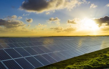 Normandy, Fransa için bulutlu gökyüzü ile gündoğumu, güneş panelleri. Güneş enerjisi, modern elektrik enerjisi üretim teknolojisi, yenilenebilir enerji kavramı. Çevre dostu elektrik üretimi