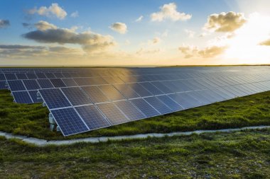 Normandy, Fransa için bulutlu gökyüzü ile gündoğumu, güneş panelleri. Güneş enerjisi, modern elektrik enerjisi üretim teknolojisi, yenilenebilir enerji kavramı. Çevre dostu elektrik üretimi