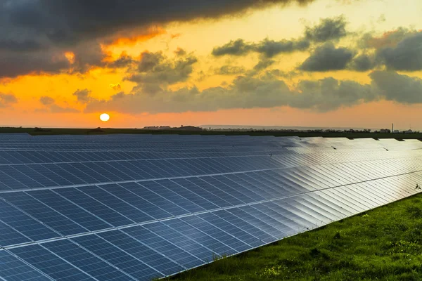 Napelemek napfelkeltekor a felhős ég a Normandy, Franciaország. Napenergia, modern villamos energia termelési technológiák, megújuló energetikai koncepció. Környezetbarát villamosenergia-termelés — Stock Fotó