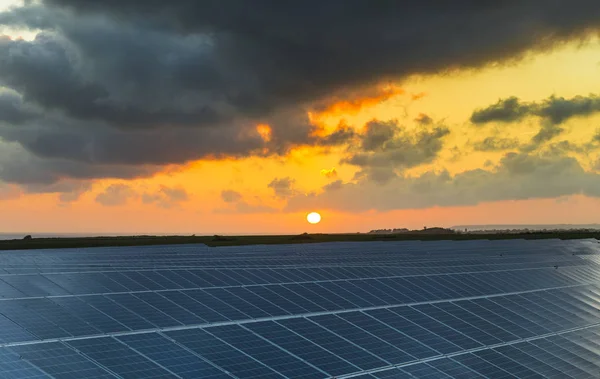 Normandy, Fransa için bulutlu gökyüzü ile gündoğumu, güneş panelleri. Güneş enerjisi, modern elektrik enerjisi üretim teknolojisi, yenilenebilir enerji kavramı. Çevre dostu elektrik üretimi