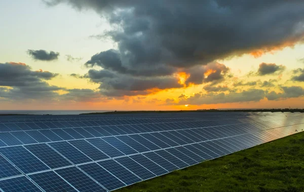 Zonnepanelen bij zonsopgang met bewolkte hemel in Normandië, Frankrijk. Zonne-energie, moderne elektrische machtstechnologie productie, hernieuwbare energieconcept. Productie van milieuvriendelijke elektriciteit — Stockfoto