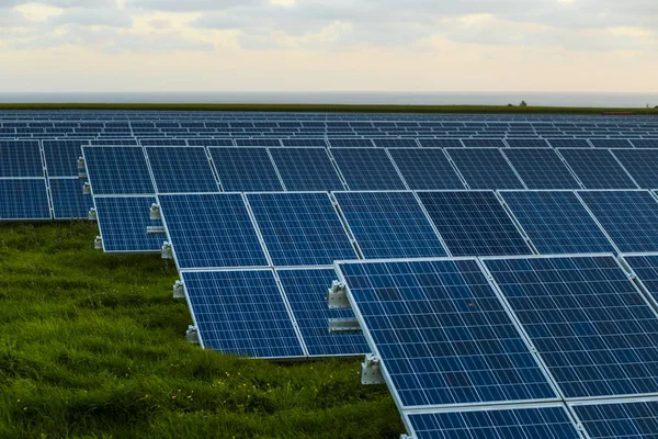 Φωτοβολταϊκά σε Ανατολή του ηλίου με συννεφιασμένο ουρανό σε Νορμανδία, Γαλλία. Ηλιακή ενέργεια, τεχνολογία παραγωγής της σύγχρονης ηλεκτρικής ενέργειας, τις ανανεώσιμες πηγές ενέργειας έννοια. Παραγωγή ηλεκτρικής ενέργειας φιλικά — Φωτογραφία Αρχείου