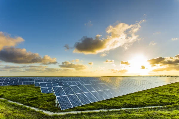 Solpaneler i soluppgången med molnig himmel i Normandie, Frankrike. Solenergi, moderna elkraft produktionsteknik, förnybar energikoncept. Miljövänlig elproduktion — Stockfoto