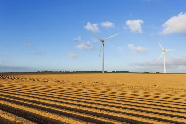 Wind turbines of a power plant for electricity generation in Normandy, France. Concept of renewable sources of energy. Agricultural fields. Environmentally friendly electricity production. Toned — Stock Photo, Image