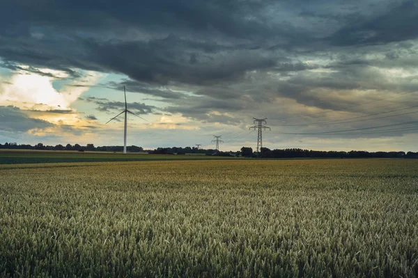 Turbine eoliche per la produzione di energia elettrica in campi agricoli verdi in Normandia, Francia. Fonti energetiche rinnovabili, concetto di agricoltura industriale. Produzione energetica rispettosa dell'ambiente — Foto Stock