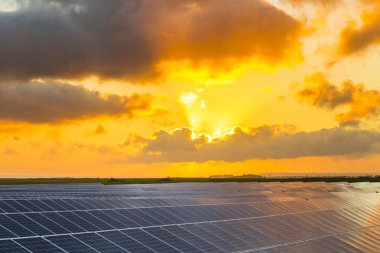Normandy, Fransa için bulutlu gökyüzü ile gündoğumu, güneş panelleri. Güneş enerjisi, modern elektrik enerjisi üretim teknolojisi, yenilenebilir enerji kavramı. Çevre dostu elektrik üretimi