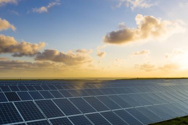 Normandy, Fransa için bulutlu gökyüzü ile gündoğumu, güneş panelleri. Güneş enerjisi, modern elektrik enerjisi üretim teknolojisi, yenilenebilir enerji kavramı. Çevre dostu elektrik üretimi