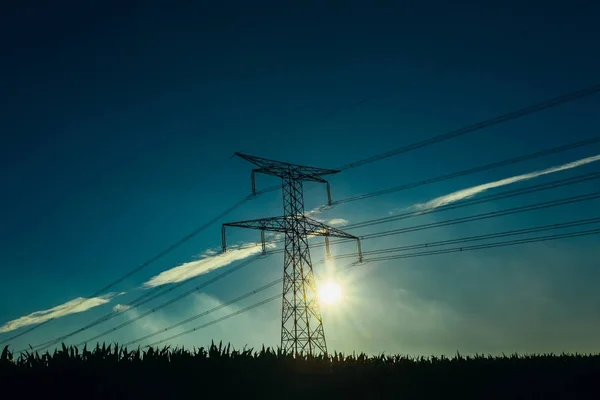 Linie wysokiego napięcia i wież transmisyjnych z promieni słonecznych w błękitne niebo w regionie Normandia, Francja. Countryside krajobraz. Wytwarzanie energii elektrycznej i dystrybucji. Elektroenergetyki i Natura — Zdjęcie stockowe