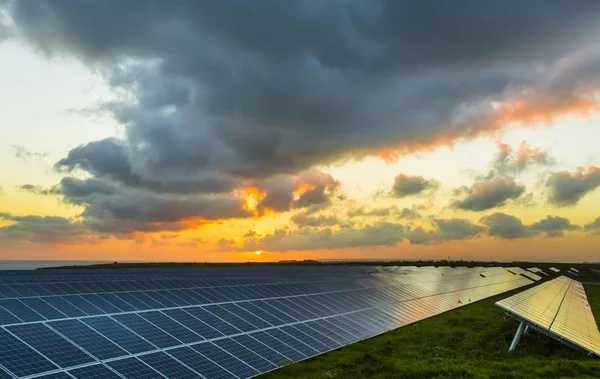 ノルマンディー、フランスの曇り空で日の出の太陽電池パネル。太陽エネルギー、モダンな電力生産技術、再生可能エネルギーの概念。環境に配慮した電力生産 — ストック写真