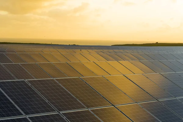 Solar panels at sunrise with cloudy sky in Normandy, France. Solar energy, modern electric power production technology, renewable energy concept. Environmentally friendly electricity production — Stock Photo, Image