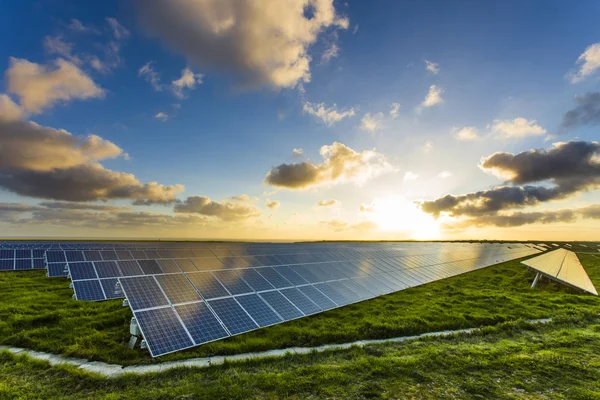 Φωτοβολταϊκά σε Ανατολή του ηλίου με συννεφιασμένο ουρανό σε Νορμανδία, Γαλλία. Ηλιακή ενέργεια, τεχνολογία παραγωγής της σύγχρονης ηλεκτρικής ενέργειας, τις ανανεώσιμες πηγές ενέργειας έννοια. Παραγωγή ηλεκτρικής ενέργειας φιλικά — Φωτογραφία Αρχείου