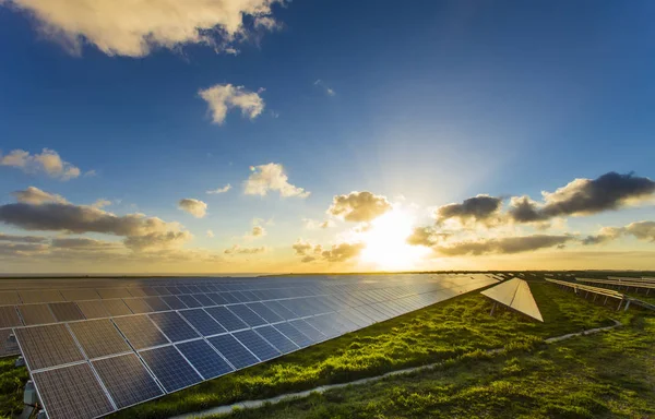 Solpaneler i soluppgången med dramatiska molnig himmel i Normandie, Frankrike. Moderna elkraft produktionsteknik. Miljövänlig elproduktion — Stockfoto