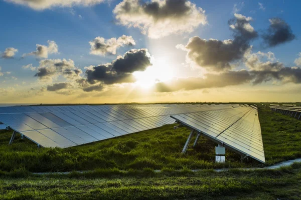 Solar panels at sunrise with dramatic cloudy sky in Normandy, France. Modern electric power production technology. Environmentally friendly electricity production — Stock Photo, Image