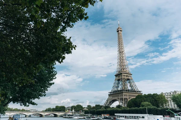 Torre Eiffel perto do rio Sena, símbolo de Paris e marco icônico na França, em um dia ensolarado brilhante. Lugares turísticos famosos e destinos de viagem românticos na Europa. Conceito de vida urbana e turismo — Fotografia de Stock