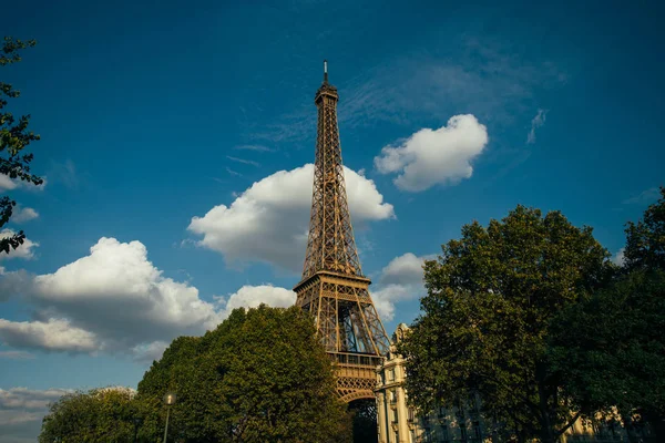 Eiffeltoren, Parijs symbool en iconische mijlpaal in Frankrijk, op een zonnige dag met wolken in de lucht. Bekende toeristische plaatsen en romantische reizen bestemmingen in Europa. Stad leven en toerisme concept — Stockfoto