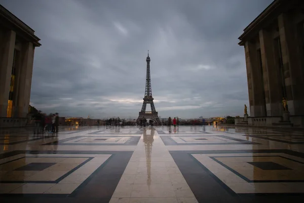 Torre Eiffel, símbolo de Paris e marco icônico na França, em um dia nublado. A paisagem urbana do crepúsculo. Lugares turísticos famosos e destinos de viagem românticos na Europa. Conceito de turismo. Longa exposição. Tonificado — Fotografia de Stock